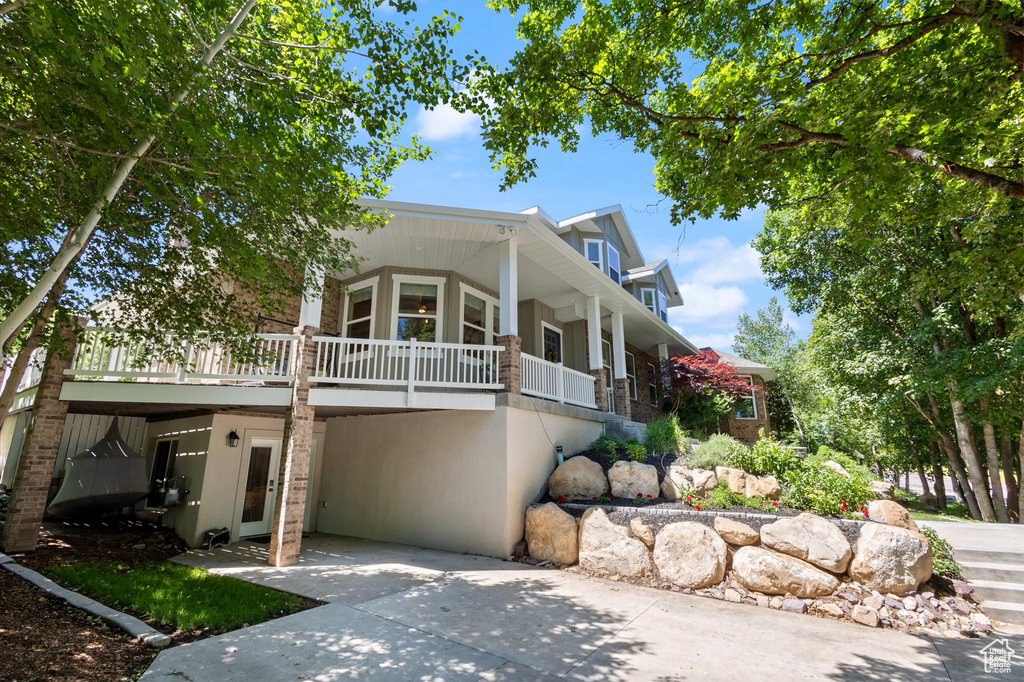 View of front facade with driveway, a carport, and stucco siding