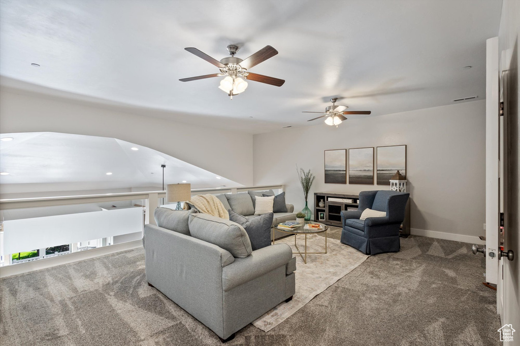 Carpeted living room featuring ceiling fan and recessed lighting
