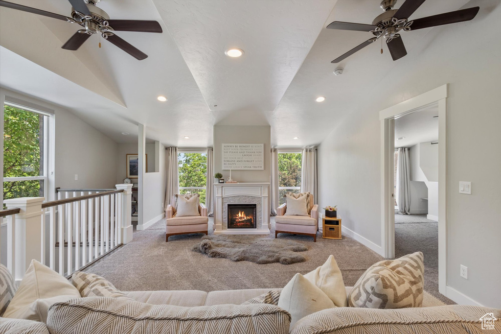 Carpeted living area with ceiling fan, healthy amount of natural light, recessed lighting, lofted ceiling, and baseboards