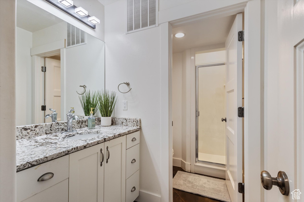 Bathroom featuring vanity, a stall shower, and recessed lighting