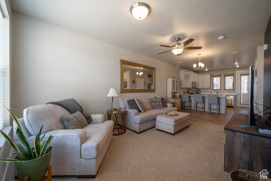 Living room featuring ceiling fan and a chandelier