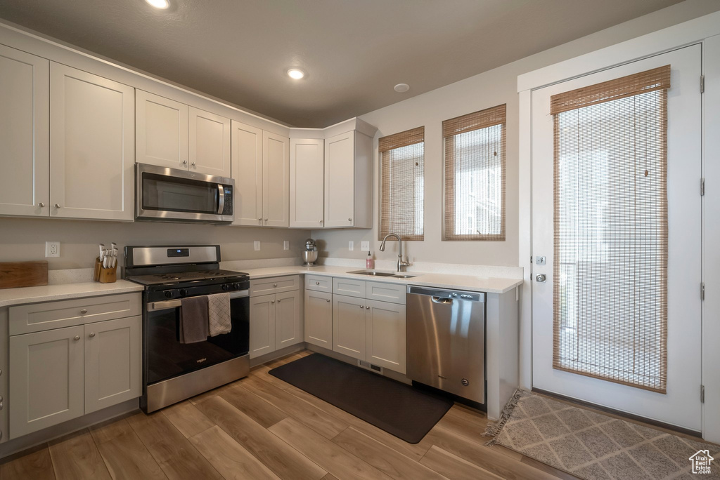 Kitchen featuring stainless steel appliances, a sink, light wood-style flooring, light countertops, and recessed lighting