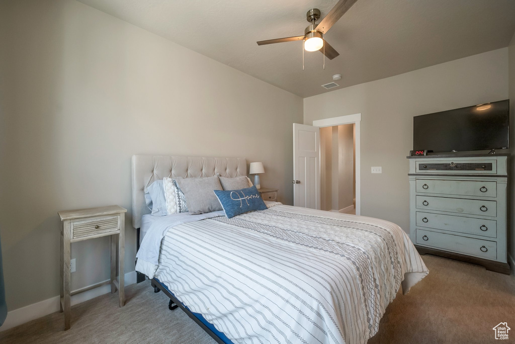 Bedroom with light colored carpet and ceiling fan