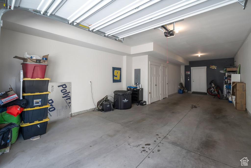 Garage featuring a garage door opener and electric panel