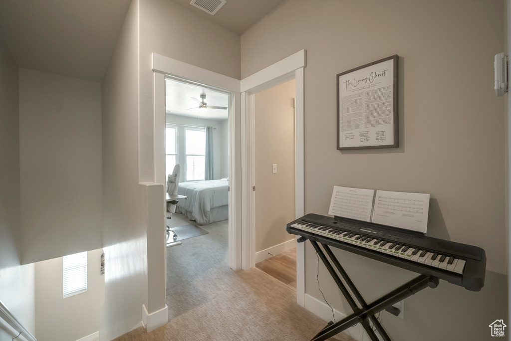 Hallway with light carpet and baseboards