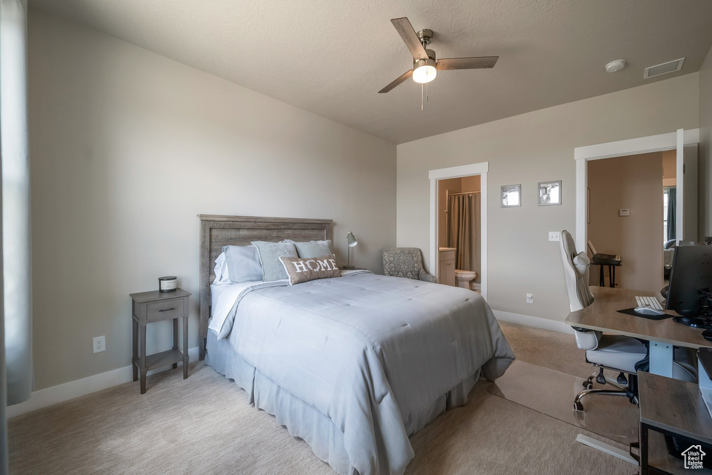 Bedroom with light carpet, an office area, baseboards, and a ceiling fan