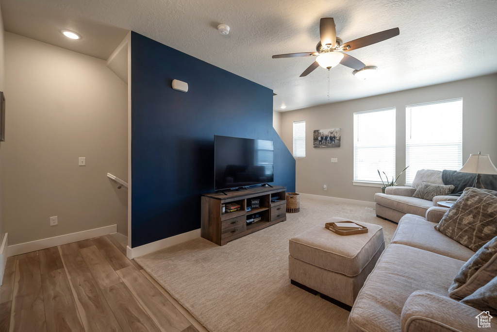 Living room featuring ceiling fan, baseboards, wood finished floors, recessed lighting, and a textured ceiling