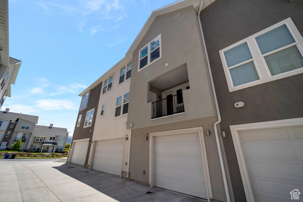 Rear view of property with stucco siding and a garage