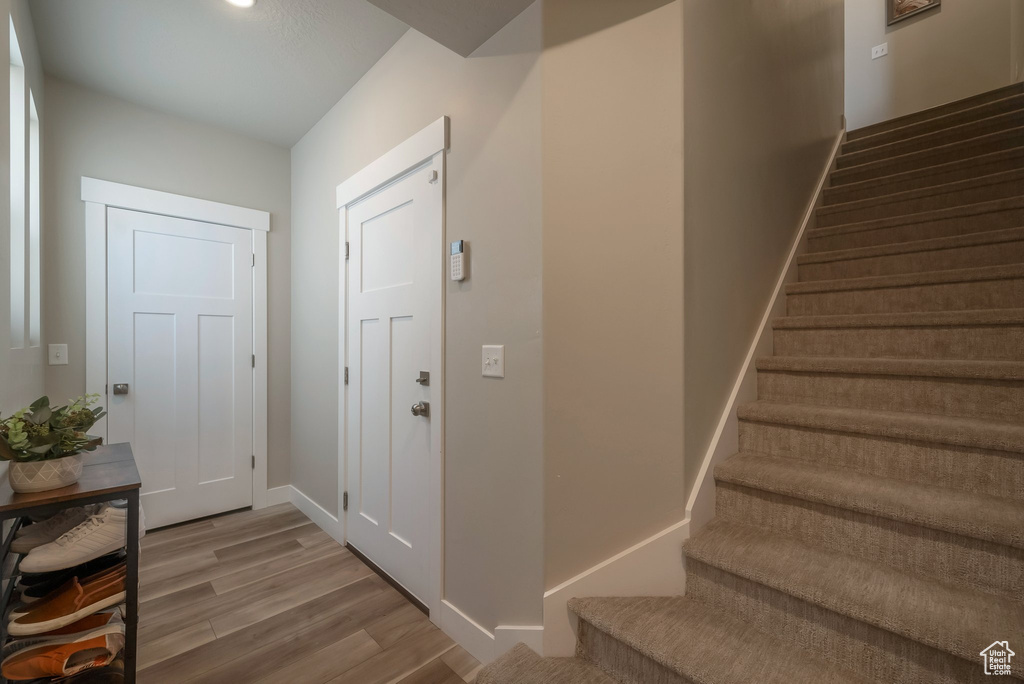 Foyer entrance featuring stairs, wood finished floors, and baseboards