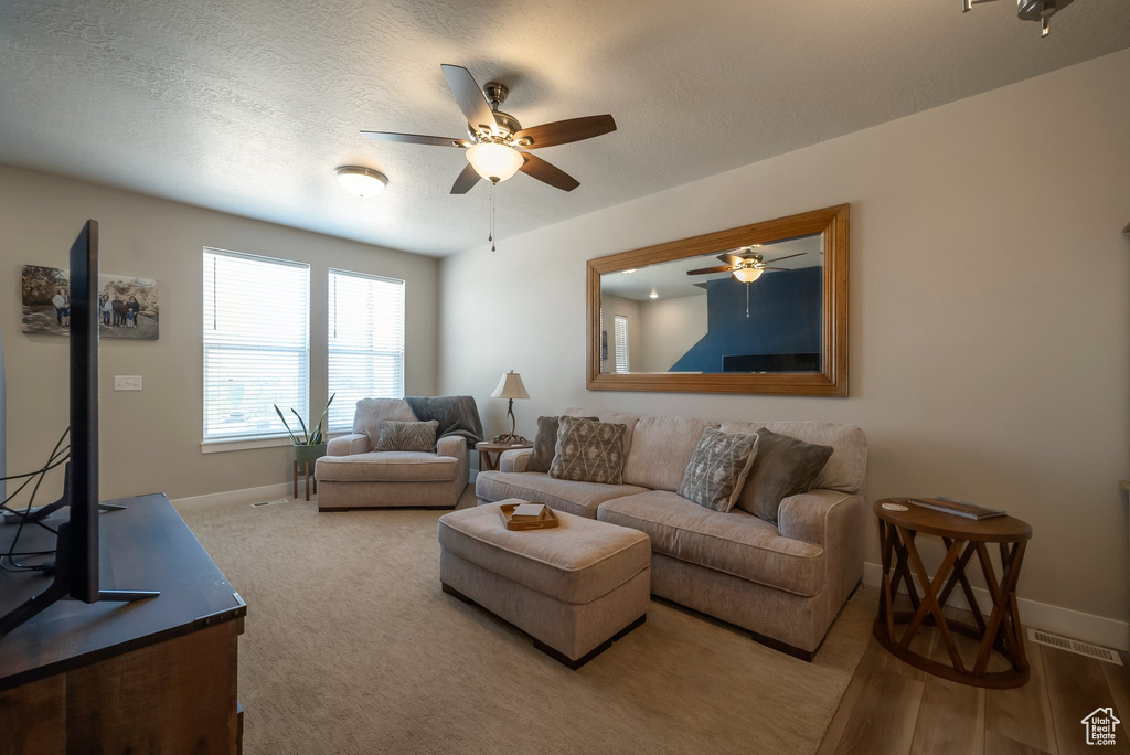 Living area with baseboards and ceiling fan