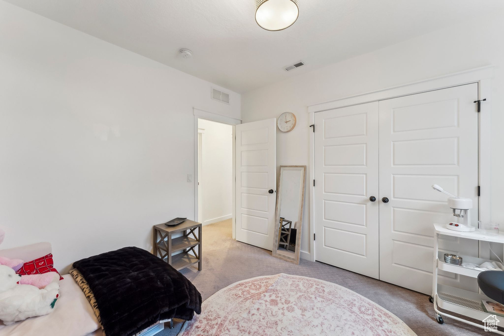 Carpeted bedroom featuring a closet