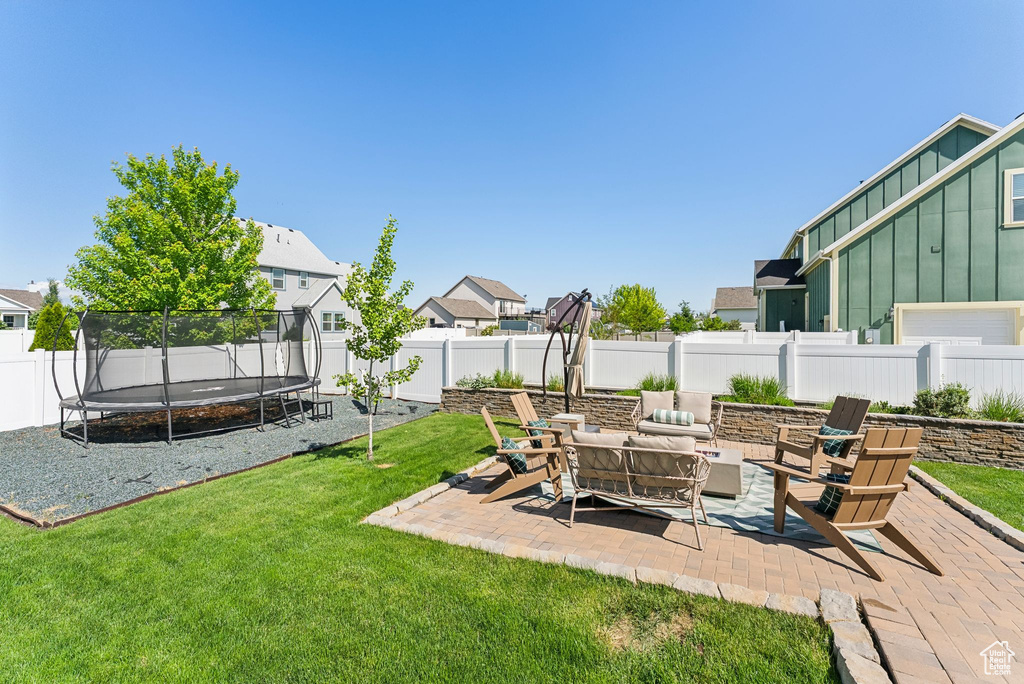 View of yard with a trampoline and a patio