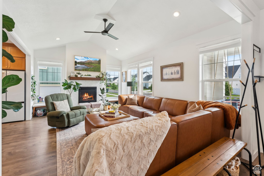 Living area featuring a fireplace, wood finished floors, lofted ceiling, a ceiling fan, and recessed lighting