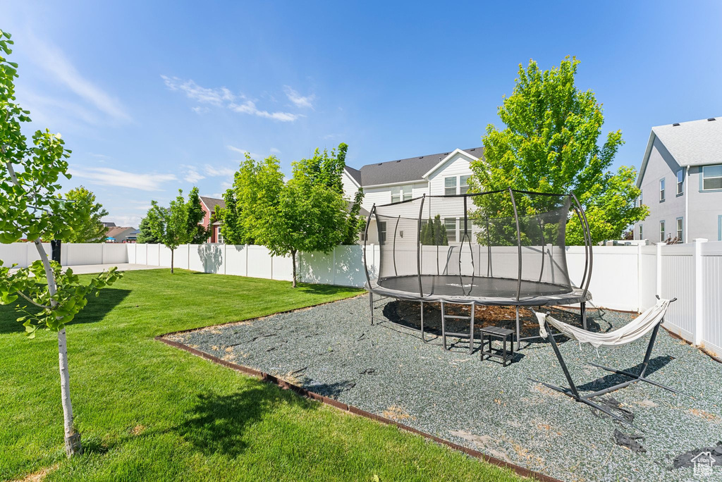View of yard featuring a trampoline and a residential view
