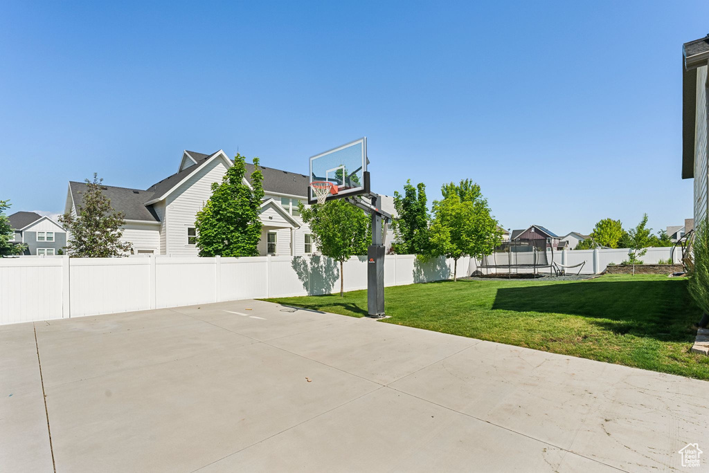 View of patio / terrace with basketball court, a trampoline, and a residential view