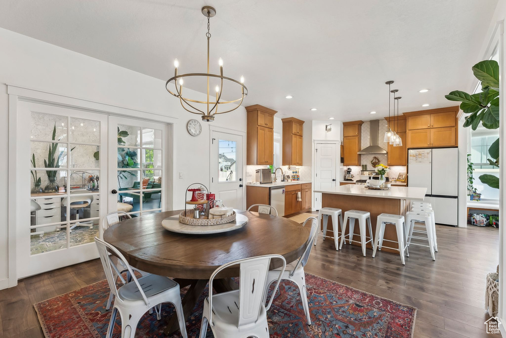 Dining room featuring a chandelier, dark wood-style floors, recessed lighting, and french doors