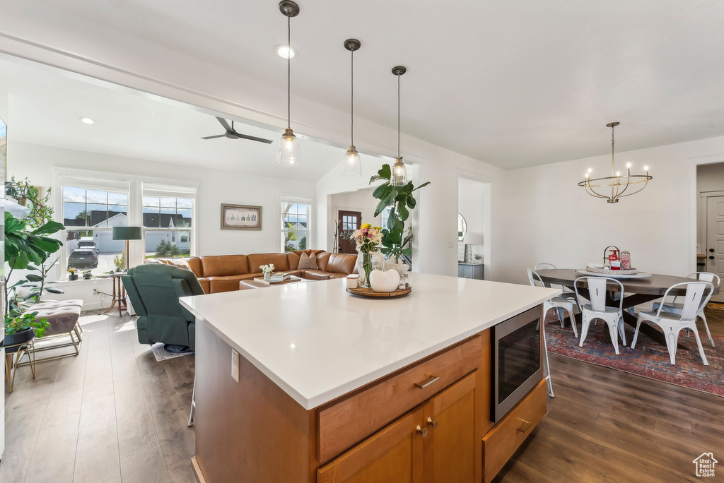 Kitchen featuring stainless steel microwave, a chandelier, dark wood finished floors, and open floor plan