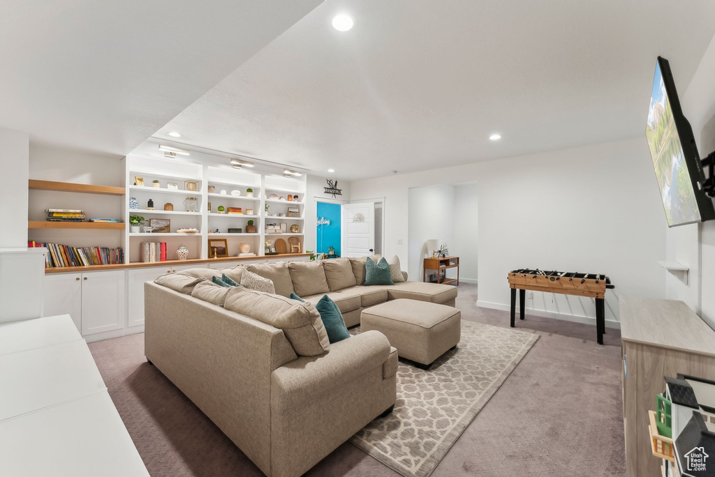 Living area with recessed lighting, light carpet, built in features, and baseboards