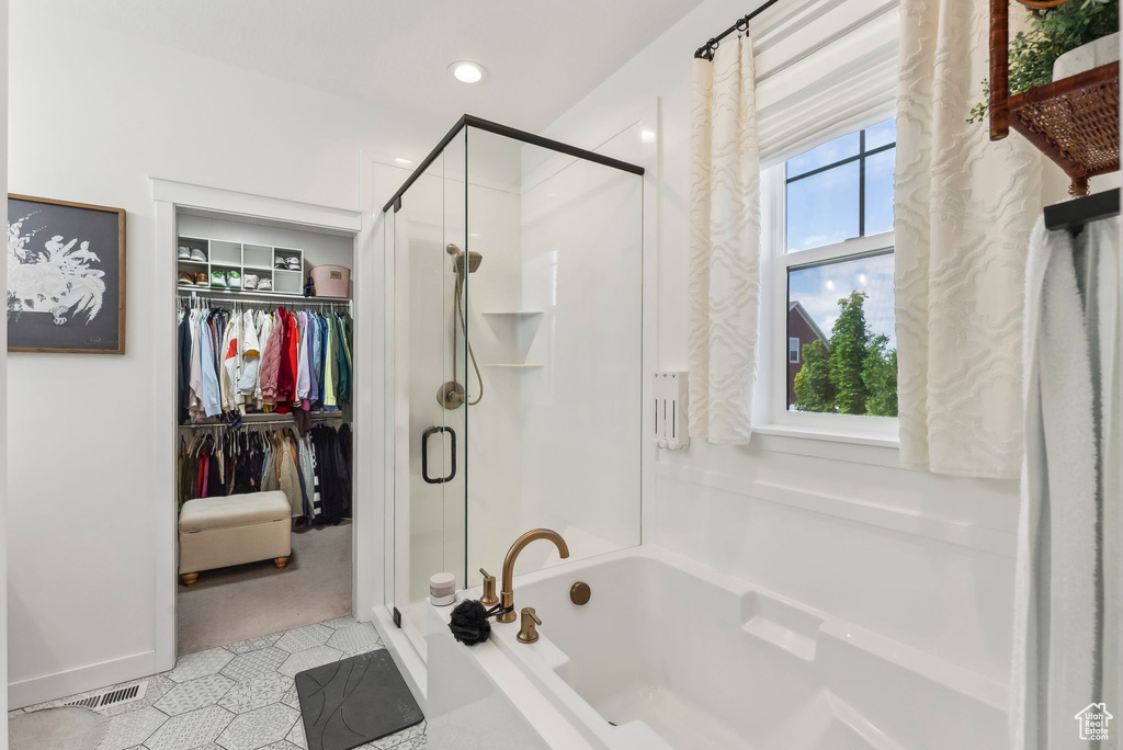 Full bathroom featuring a bath, a shower stall, a spacious closet, tile patterned flooring, and recessed lighting