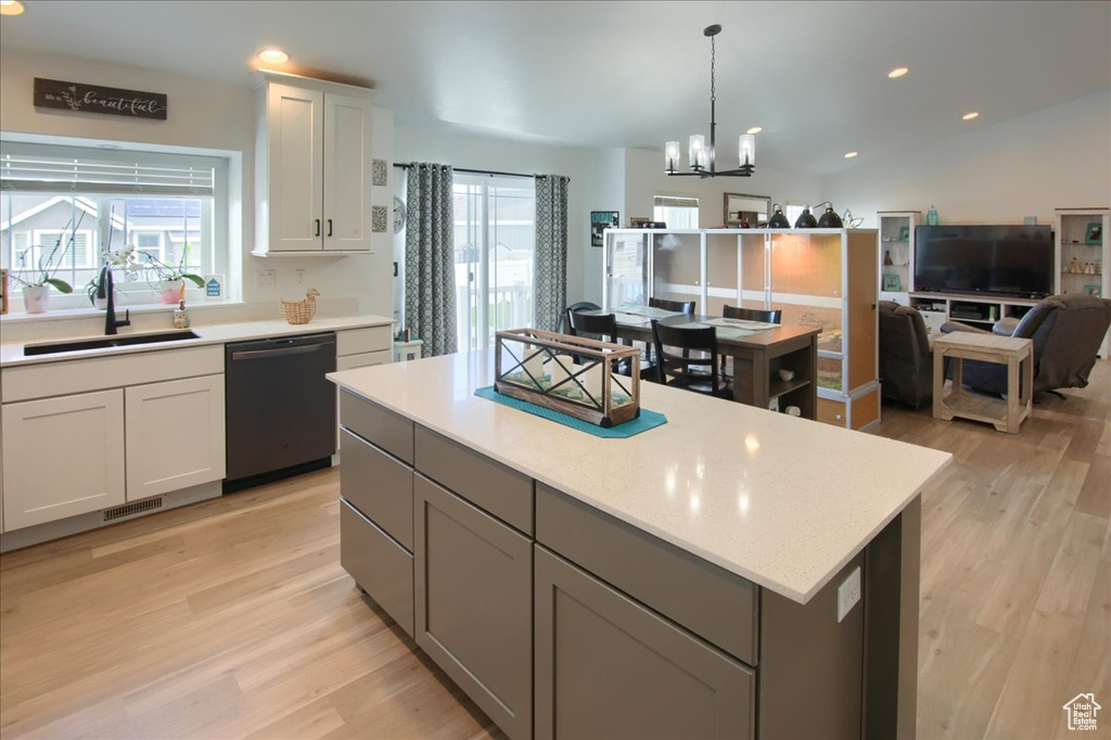Kitchen featuring black dishwasher, a sink, light wood-style floors, a chandelier, and recessed lighting