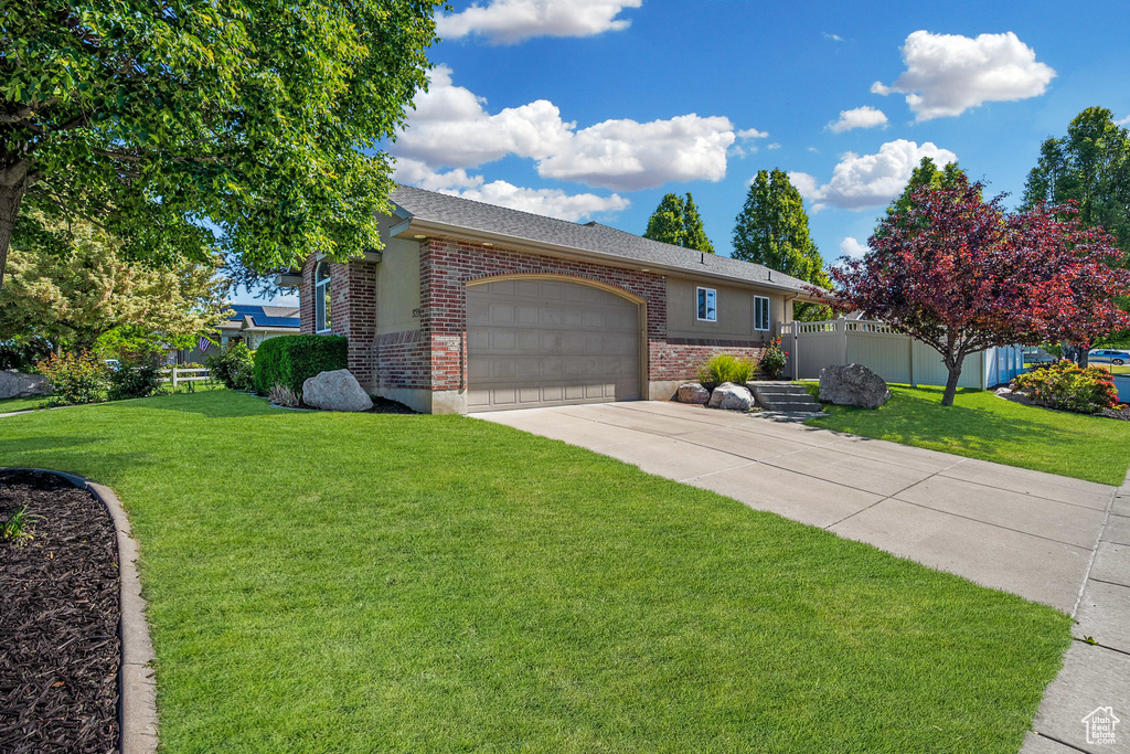 View of front of house featuring brick siding, driveway, a garage, and roof with shingles