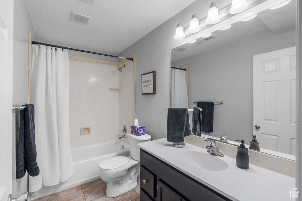 Full bath with vanity, toilet, shower / tub combo with curtain, and tile patterned floors