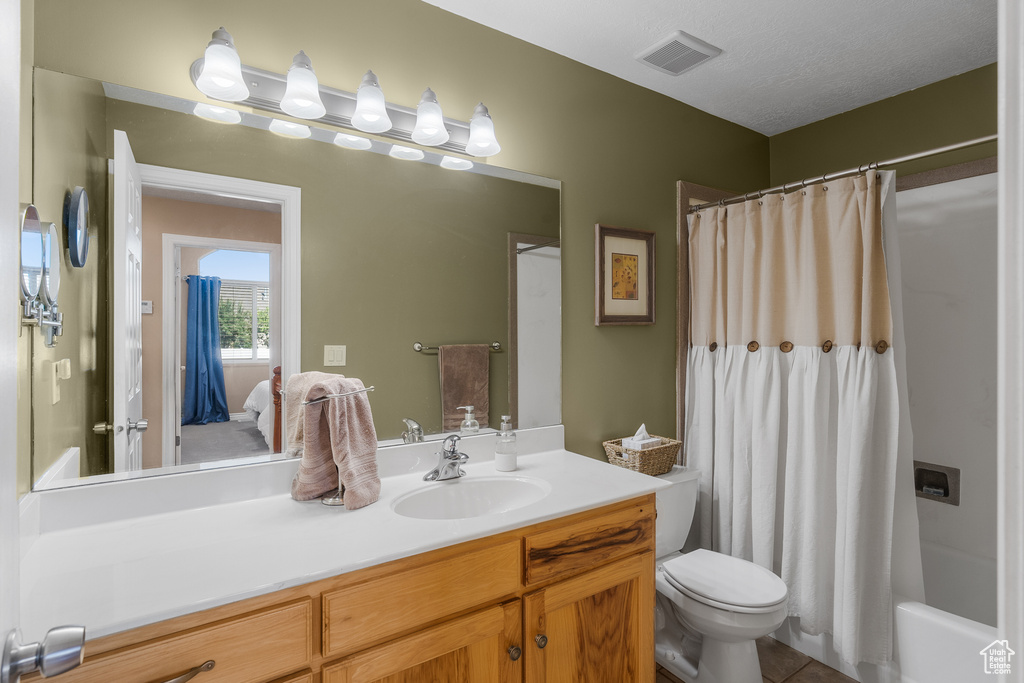 Full bathroom with vanity, toilet, shower / tub combo with curtain, and tile patterned floors