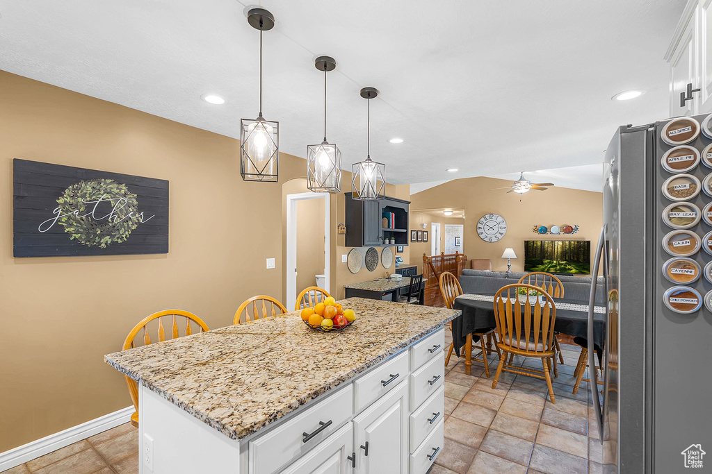Kitchen with freestanding refrigerator, white cabinetry, a ceiling fan, recessed lighting, and light stone countertops