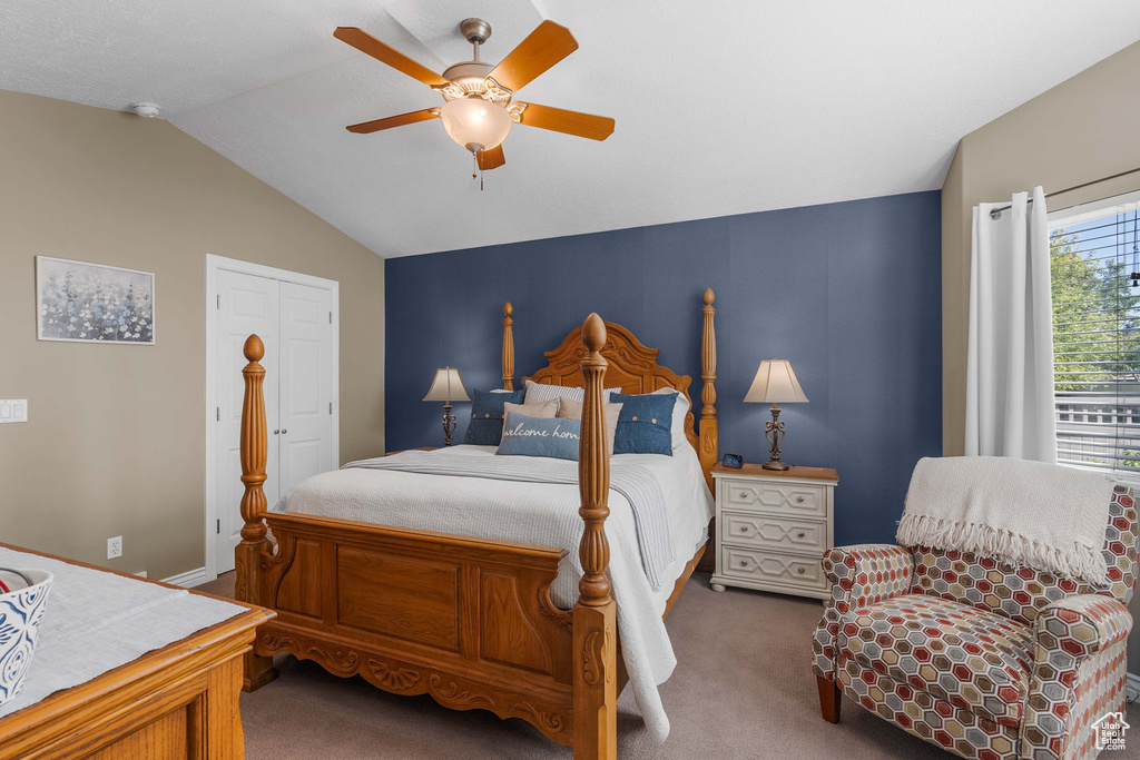 Carpeted bedroom with lofted ceiling and ceiling fan