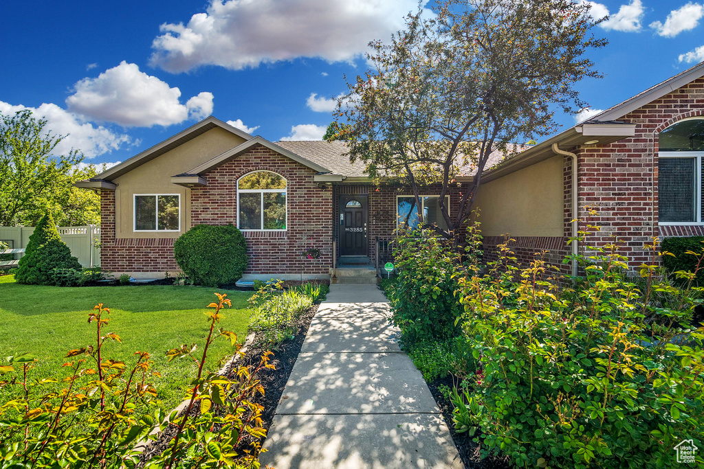 View of front facade featuring brick siding and stucco siding