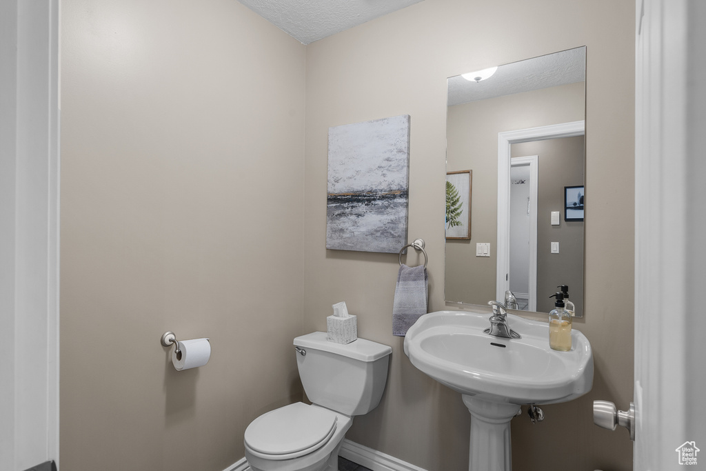 Bathroom with toilet and baseboards