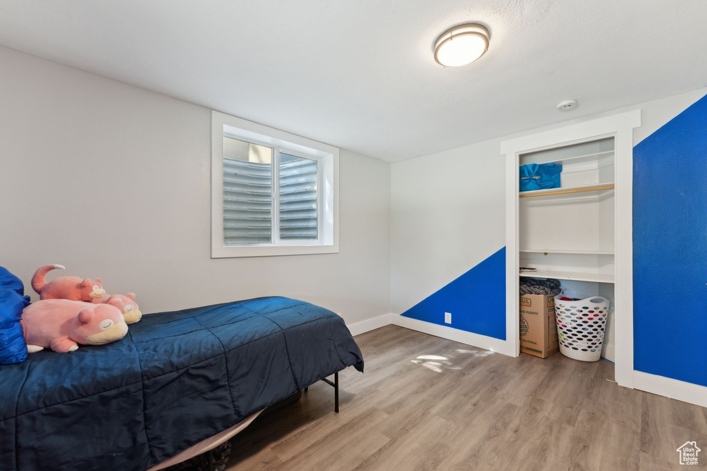 Bedroom with wood finished floors and baseboards