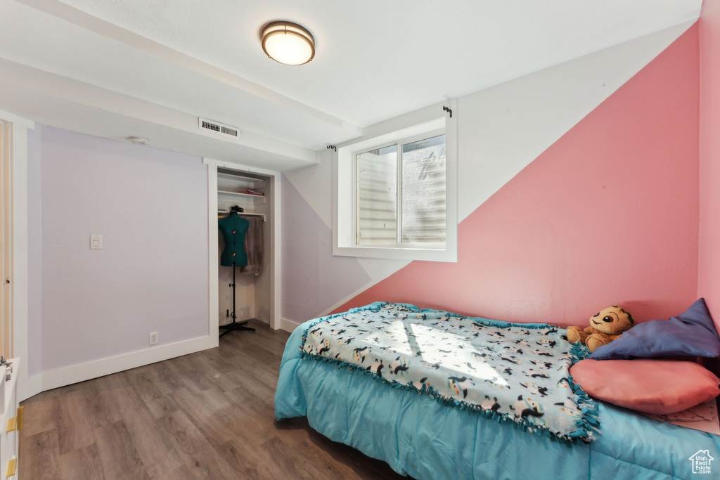 Bedroom with wood finished floors and baseboards