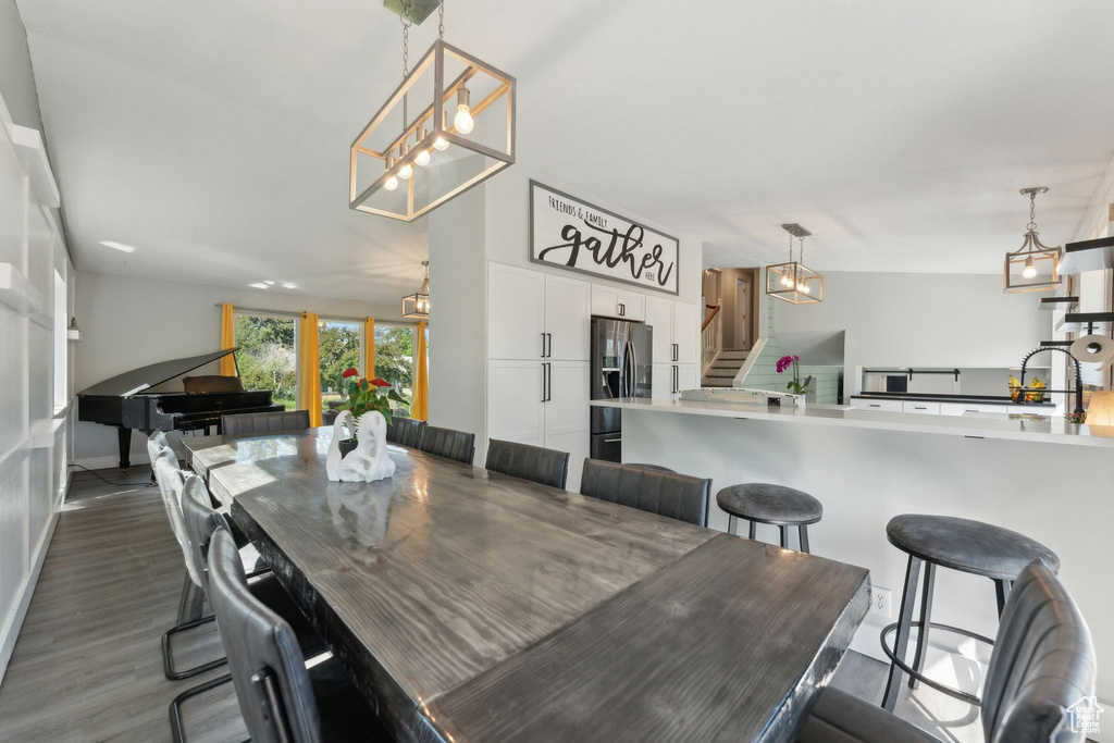Dining room featuring stairs, a chandelier, and dark wood finished floors