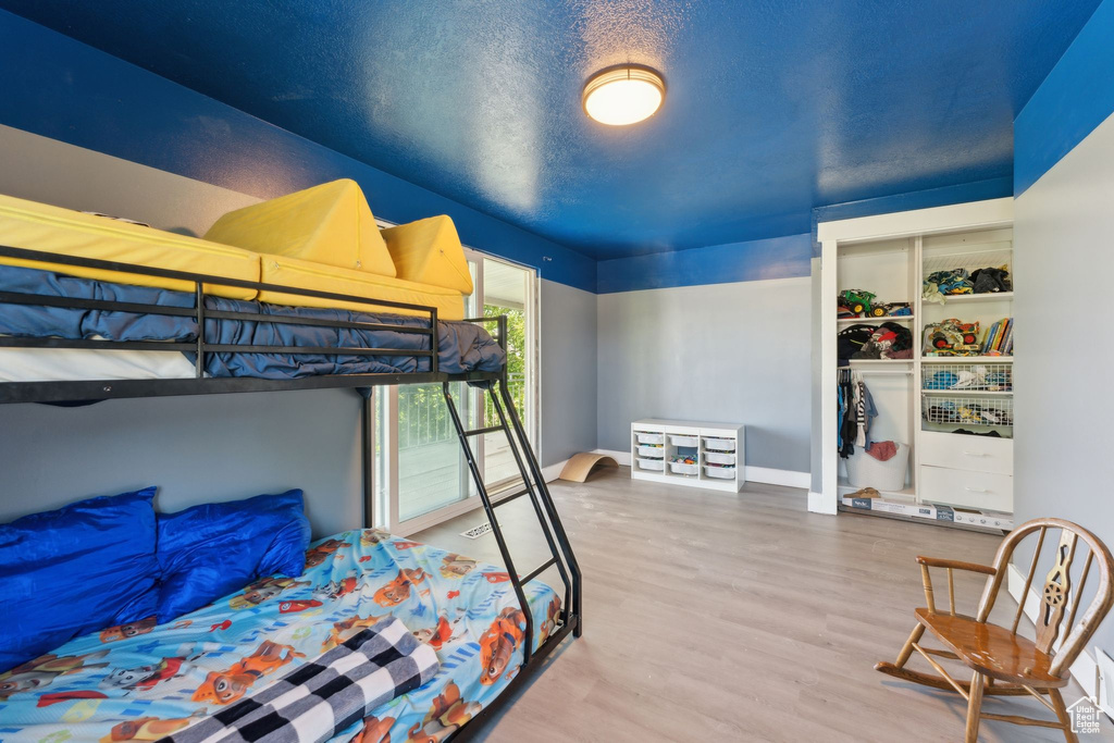 Bedroom with wood finished floors and a closet