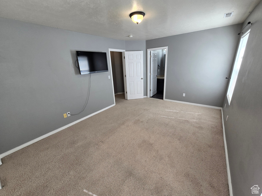 Unfurnished bedroom with baseboards, carpet, and connected bathroom