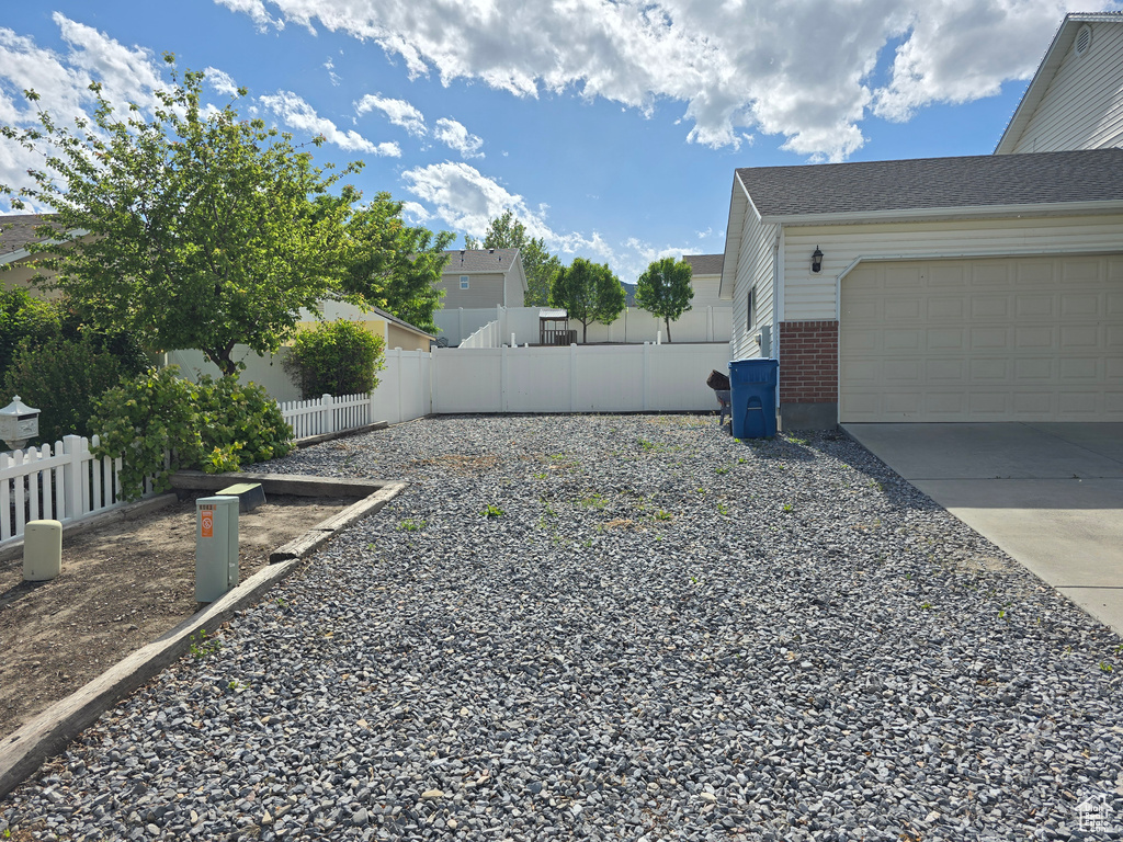 View of yard with concrete driveway and an attached garage