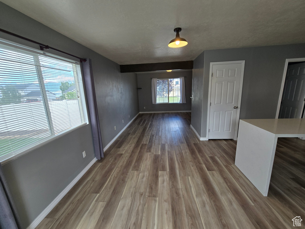 Unfurnished dining area featuring dark wood finished floors and baseboards