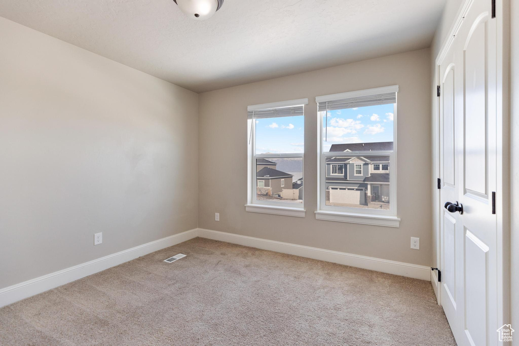 Carpeted empty room featuring baseboards