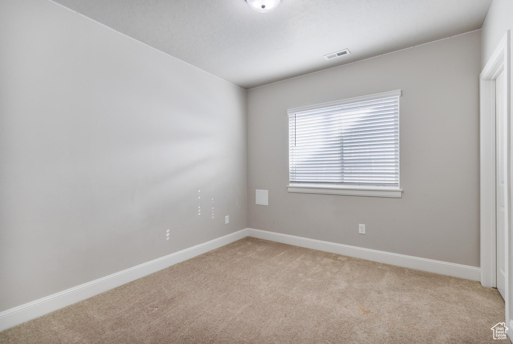 Unfurnished room featuring light colored carpet and baseboards