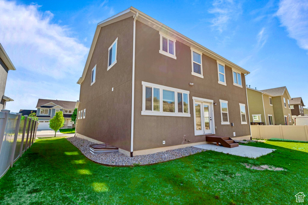 Back of house with stucco siding, a patio area, and french doors
