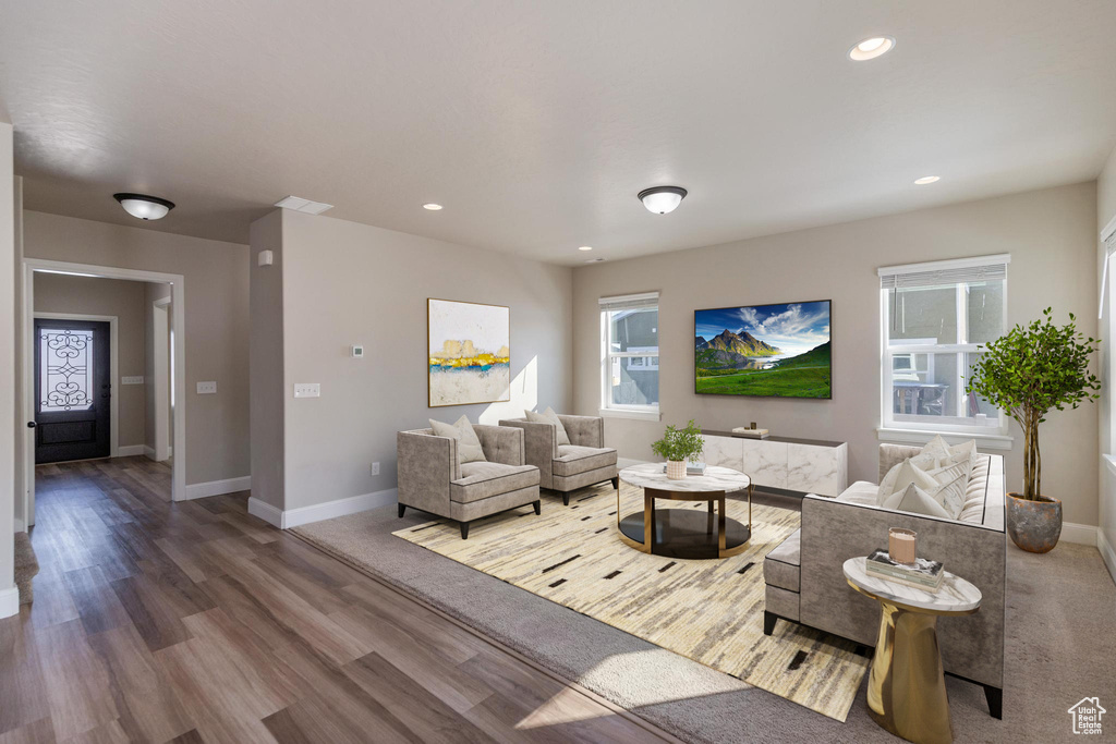 Living room with baseboards, wood finished floors, and recessed lighting