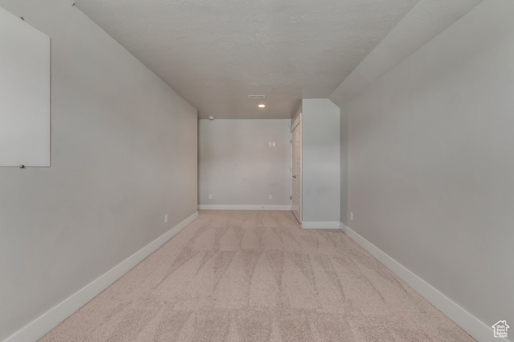 Unfurnished room featuring light colored carpet, baseboards, and recessed lighting