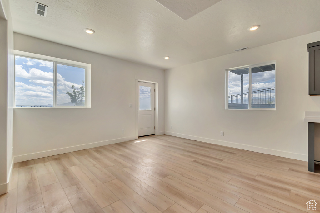 Unfurnished living room featuring light wood finished floors, baseboards, and recessed lighting