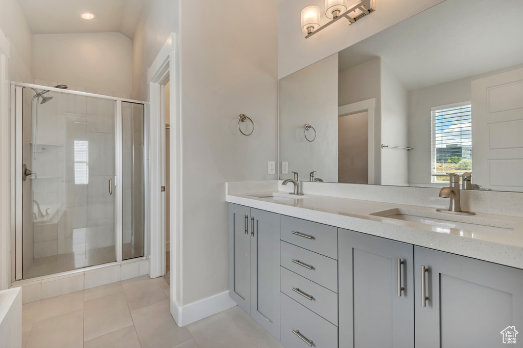 Bathroom featuring double vanity, a stall shower, tile patterned flooring, baseboards, and recessed lighting
