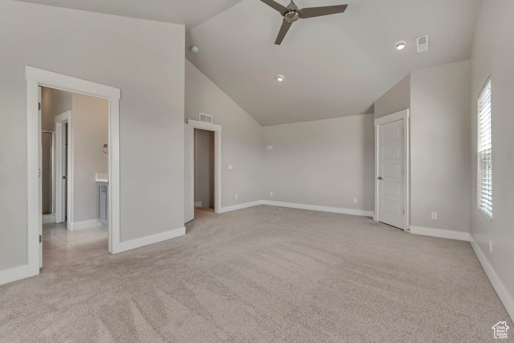 Unfurnished bedroom with light carpet, vaulted ceiling, baseboards, recessed lighting, and ensuite bathroom