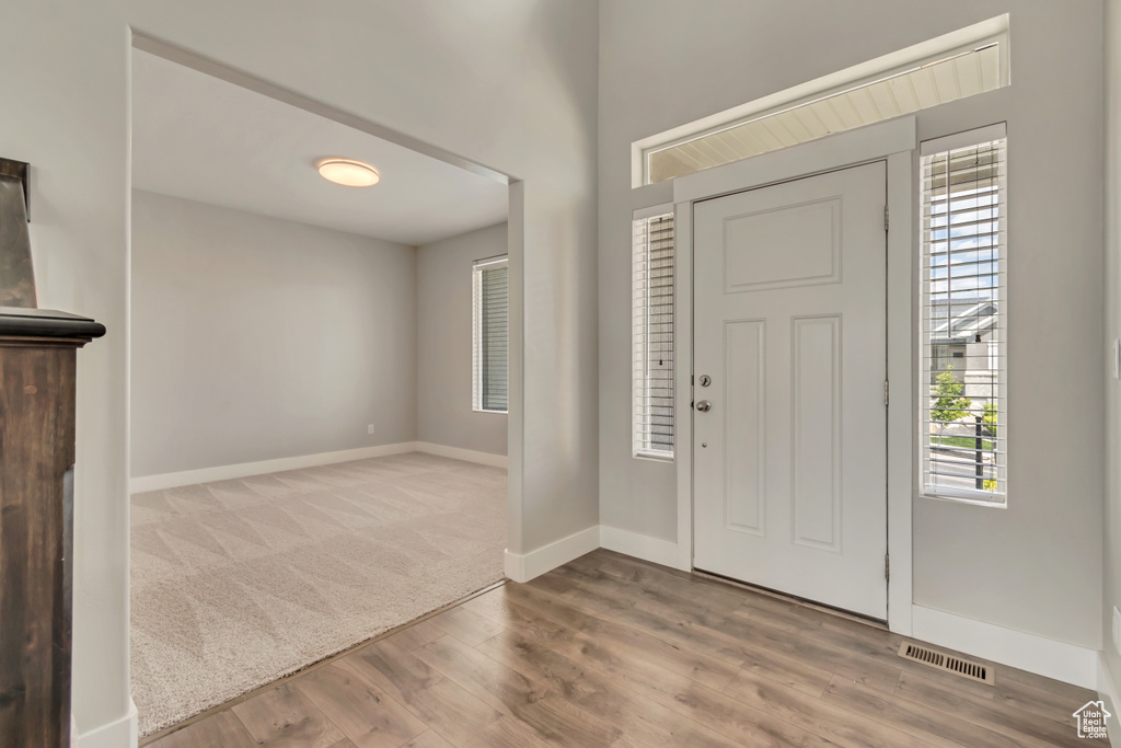 Carpeted entrance foyer featuring wood finished floors and baseboards