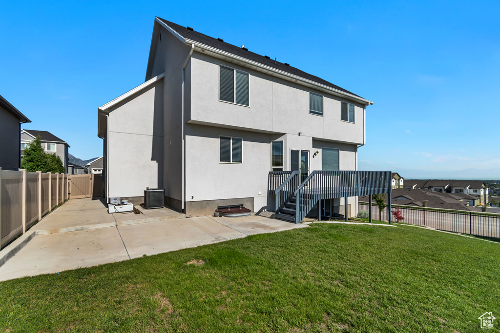 Rear view of house with stucco siding, a patio, central AC unit, and a deck