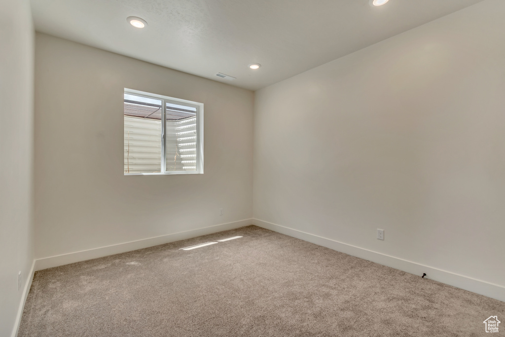 Empty room featuring carpet, recessed lighting, and baseboards
