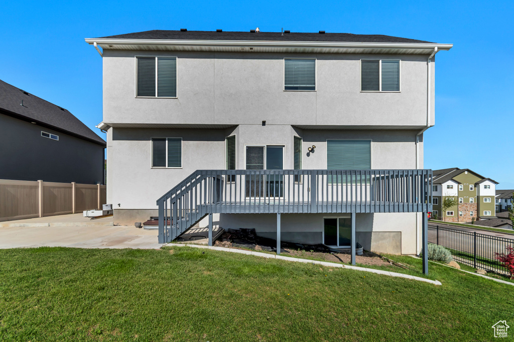 Back of house with a patio area, stucco siding, and a deck
